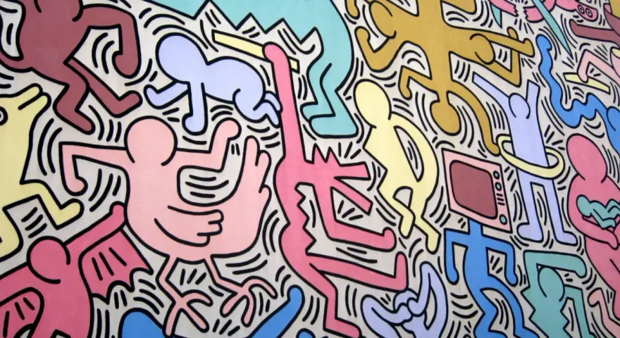 Une fresque colorée de Keith Haring, œuvre la plus connue, avec des figures stylisées dansant et interagissant, un chien jaune, un bébé et une télévision.