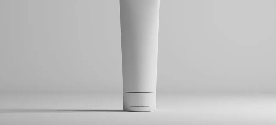 Tubo bianco minimalista, con un sottile anello scuro, che contiene una formula con hydroxypropyl starch phosphate per una pelle liscia.