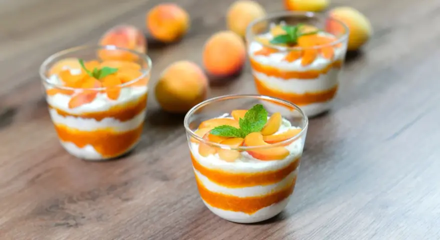 Cremige Desserts mit Aprikosenmus und Sahne, garniert mit frischen Aprikosenstücken und Minze. Eine köstliche Alternative zu shaved ice.