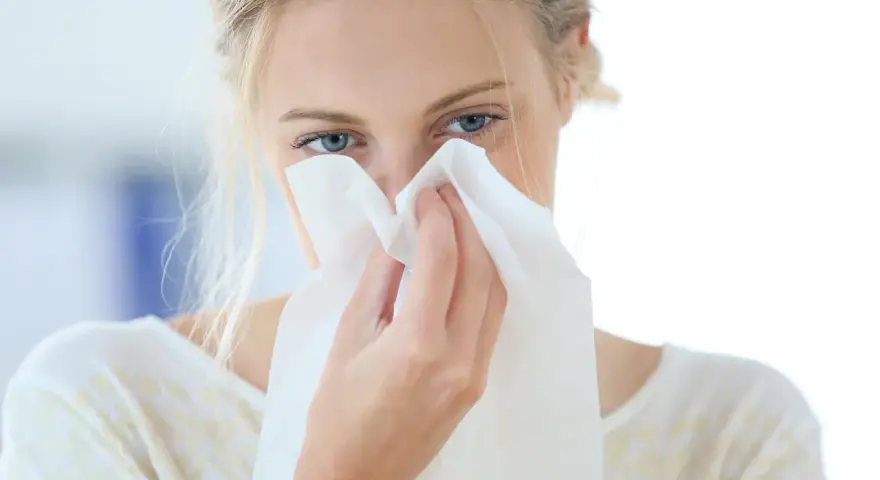 Donna con fazzoletto nasale, forse soffre di allergia aria condizionata.