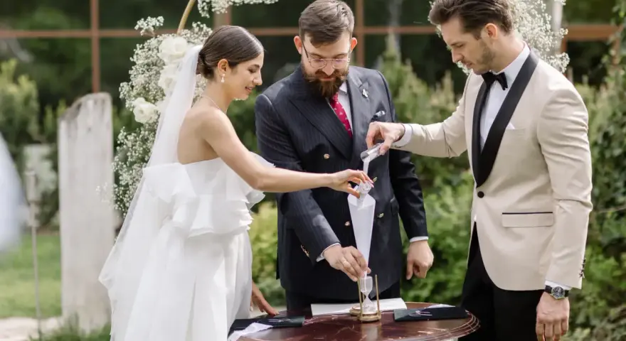 Para młoda podczas ceremonii, w tle łuk weselny. Zastanawiasz się nad wedding planner cena?