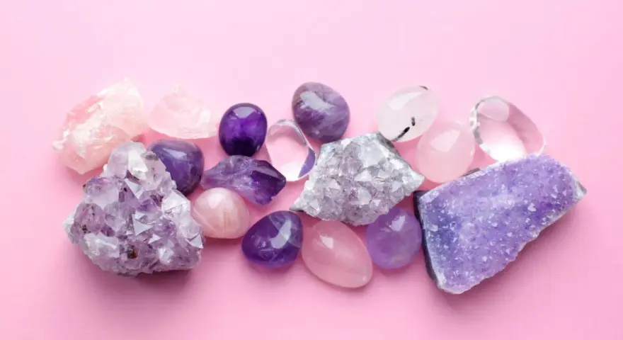Cristales de amatista, cuarzo rosa y transparente sobre fondo rosa. El jade blanco significado se asocia a la pureza y la serenidad.