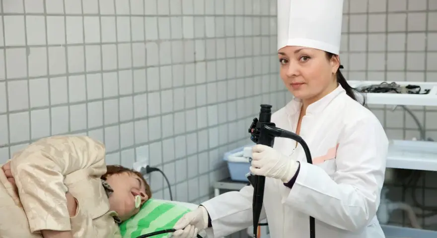 Lekarka przygotowuje pacjenta do gastroskopii. Przed badaniem ważne jest, co można jeść dzień przed gastroskopią – zazwyczaj lekkostrawne posiłki.