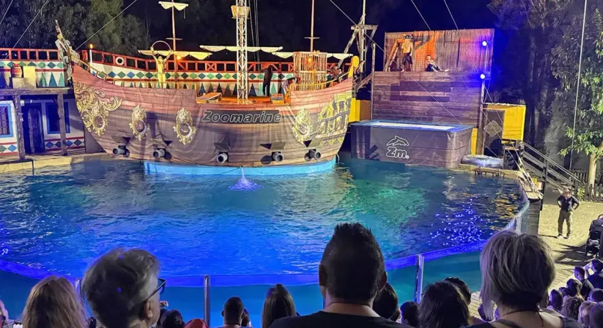 A pirate ship show at Zoomarine Roma with performers on a stage and in the water.