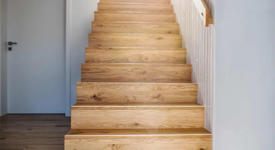 Holztreppe mit beleuchteten Treppenstufen verkleiden. Natürliche Holzmaserung und schlichtes Design.
