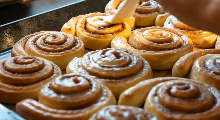 Saftige Zimtschnecken werden mit Glasur überzogen. Ein köstliches Zimtschnecken Rezept, das jeden begeistert.