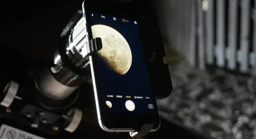 Mit dem Handy den Mond fotografieren: Ein Smartphone ist über einen Adapter an einem Teleskop befestigt, um den Mond abzulichten.