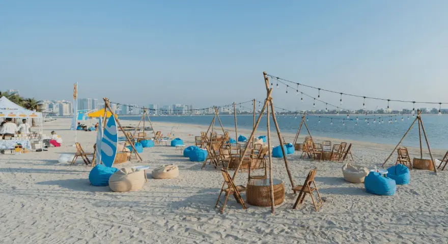 Plaża w Dubaju w lipcu: leżaki, stoliki i girlandy świateł tworzą letnią atmosferę.