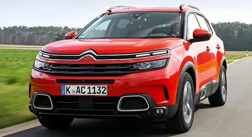 Roter Citroën C5 Aircross fährt auf einer Landstraße. Trotz seines modernen Designs gibt es Berichte über Citroën C5 Aircross Probleme.