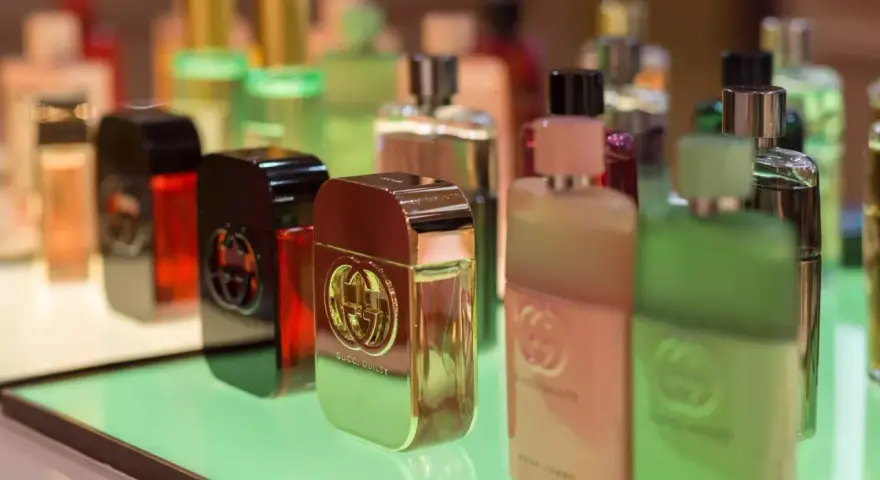 Butelki perfum Gucci Guilty na zielonym podświetlanym tle.