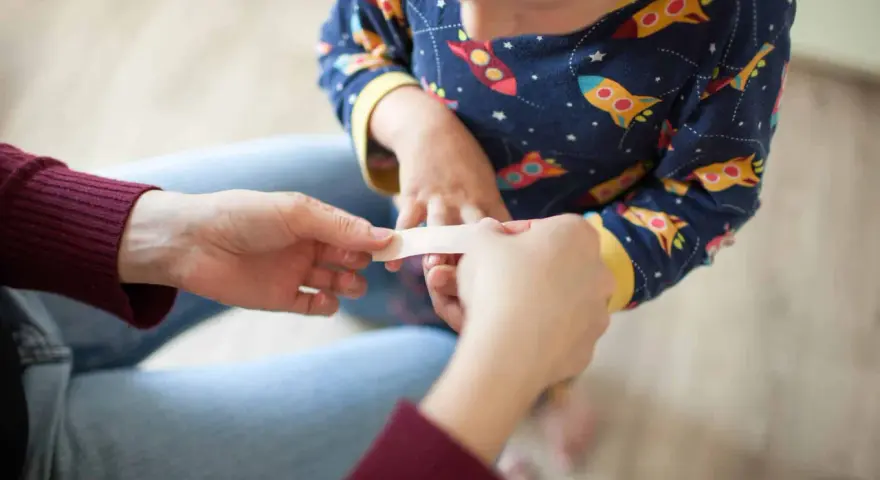 Un pansement appliqué sur un petit doigt, un remède grand-mère brûlure main réconfortant.