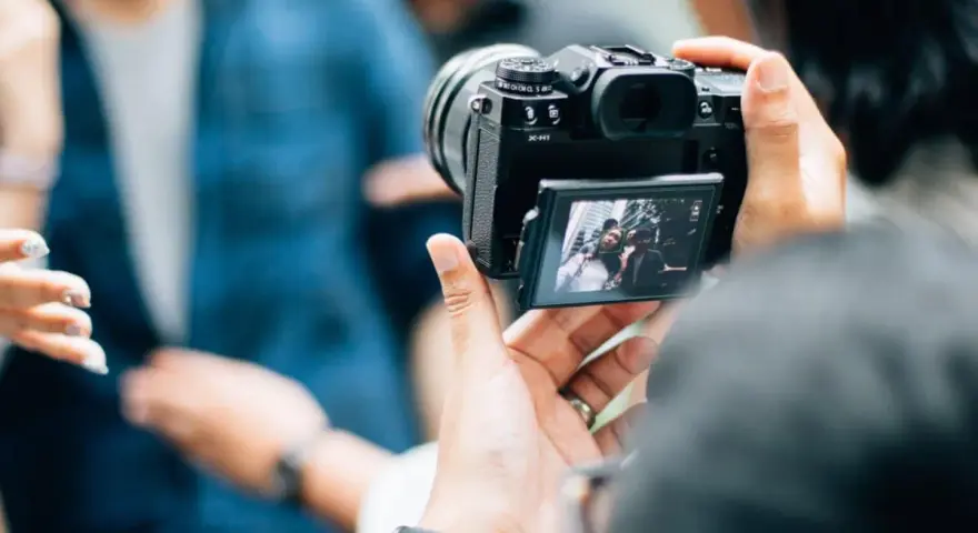 Je découvre la photographie, capturant un selfie de groupe avec un appareil photo moderne.