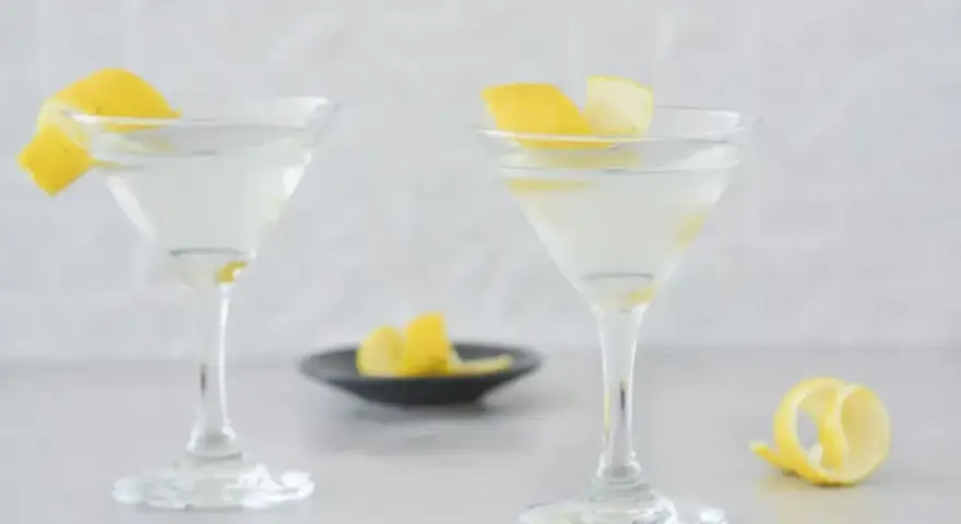 Dwa martini z cytrynową skórką, idealne do przepisu na Dirty Martini.