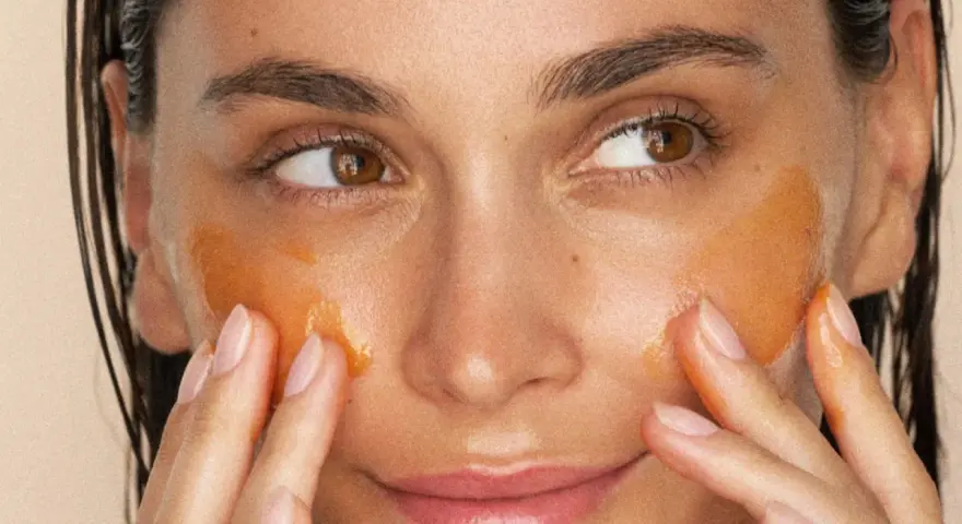 Application d'un masque aloe vera visage. La peau est hydratée et lumineuse, les doigts massent doucement le produit.