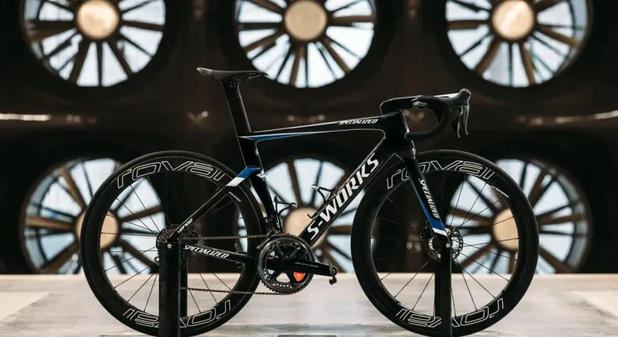 A black S-Works aero bike, designed for speed, is showcased in front of large industrial fans. This is what an aero bike looks like.
