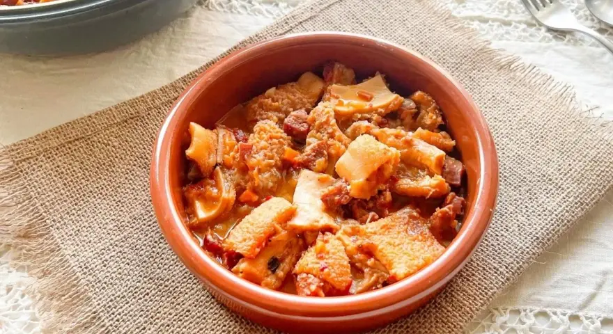 Un cuenco de barro con callos a la vizcaina, un plato tradicional español lleno de sabor y textura.
