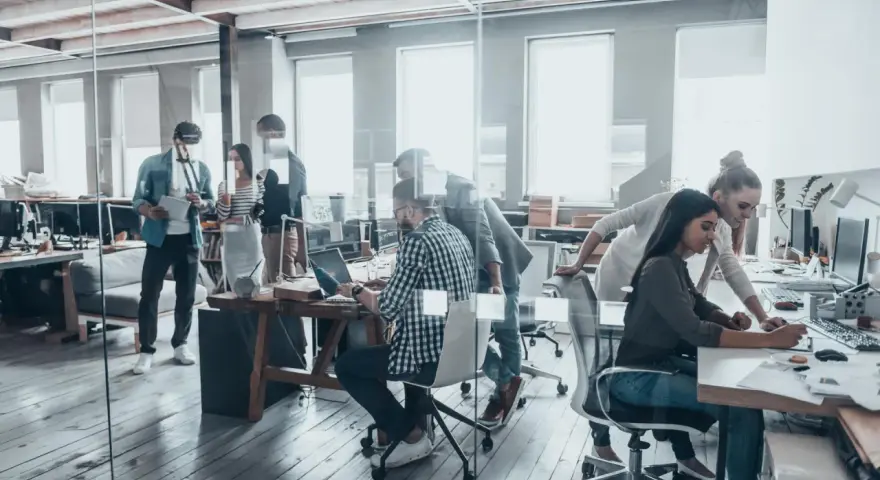 Persone lavorano in un ufficio moderno, un esempio di coworking cos'è: collaborazione e flessibilità in un ambiente dinamico.