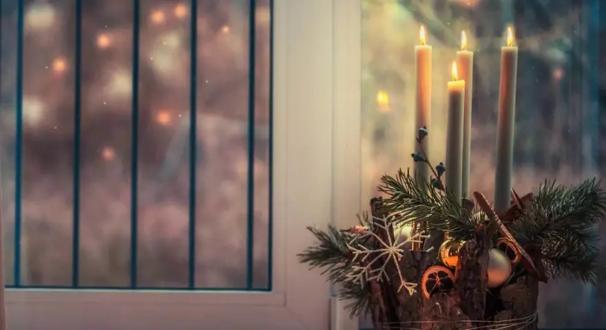 Four lit candles on an Advent wreath, ready for the 4th Sunday of Advent readings.
