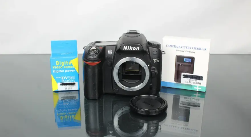 Nikon D80 z akcesoriami: ładowarka i bateria do aparatu cyfrowego.