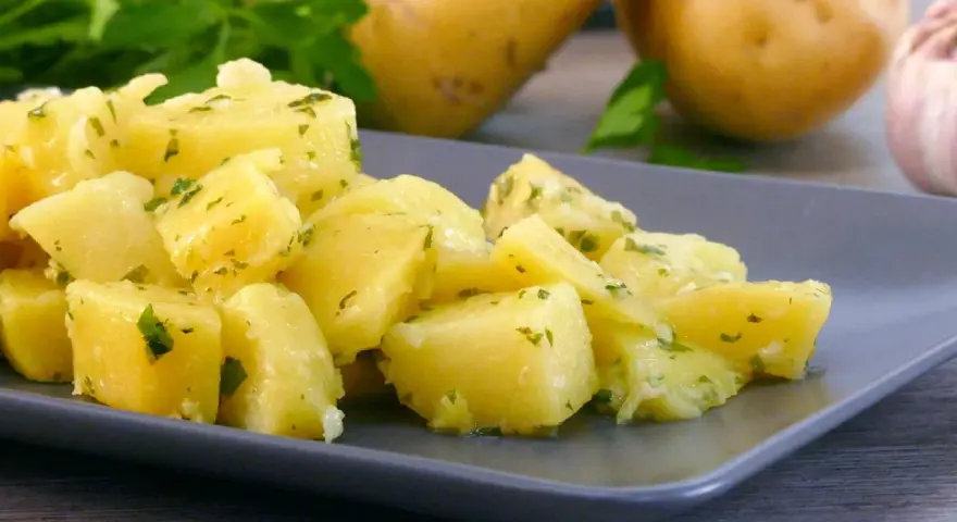Patatas al microondas cortadas en cubos, aliñadas con perejil y ajo. Un plato sencillo y delicioso.