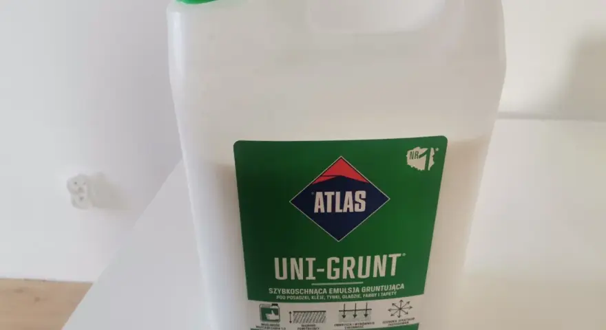 Biały kanister z zieloną nakrętką. Etykieta: "ATLAS UNI-GRUNT SZYBKOSCHNĄCA EMULSJA GRUNTUJĄCA". Dowiedz się, jak stosować ten produkt.