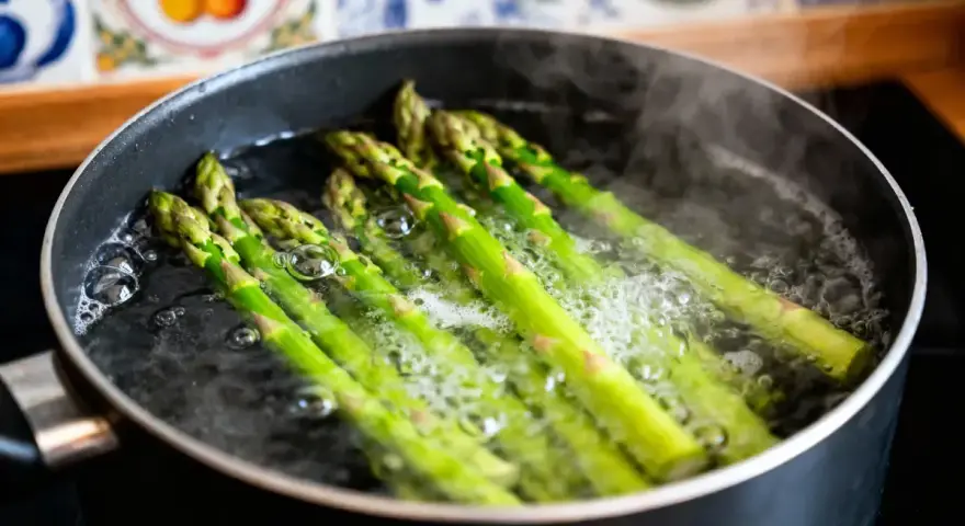 Asperges vertes bouillonnant dans une casserole, prêtes pour une recette simple et savoureuse.