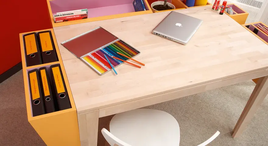 Ein heller Schreibtisch, perfekt zum **schreibtisch selber bauen**, mit Buntstiften, Laptop und Ordnern.