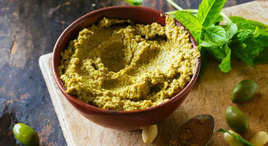 Zielona pasta z oliwek, idealna do smarowania pieczywa, jako dodatek do dań lub dip.
