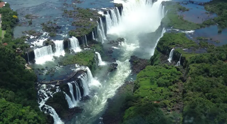 An aerial view of Iguazu Falls, a breathtaking cascade of water surrounded by lush green jungle. A perfect destination for 2 days of unforgettable adventure.