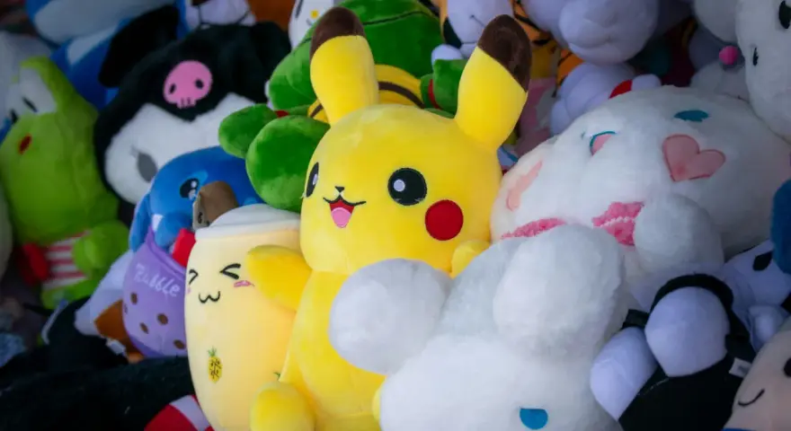 Pluszaki, jak Pikachu i króliczek, czekają na pranie. Kolorowe, miękkie zabawki w różnych kształtach.