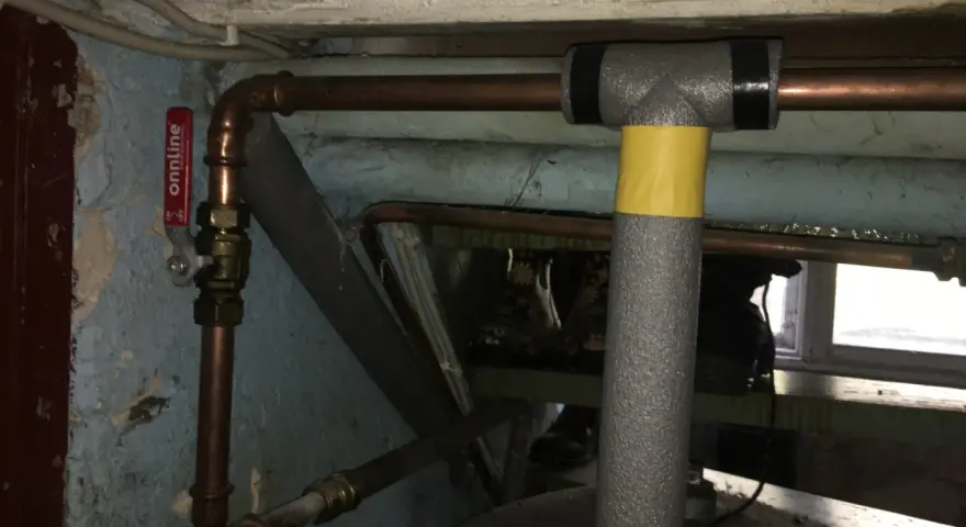 Kopparrör med isolering och en röd ventil, redo att fylla på luft i hydrofor.