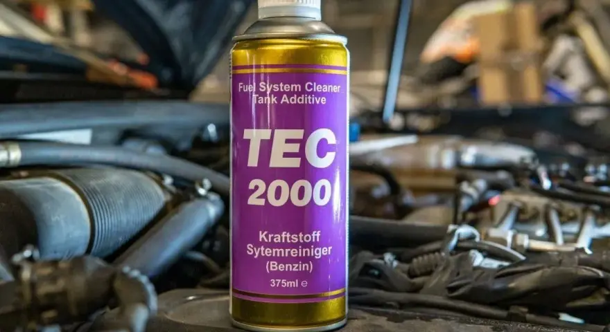 Puszka TEC 2000 do czyszczenia układu paliwowego benzyny, umieszczona w komorze silnika.