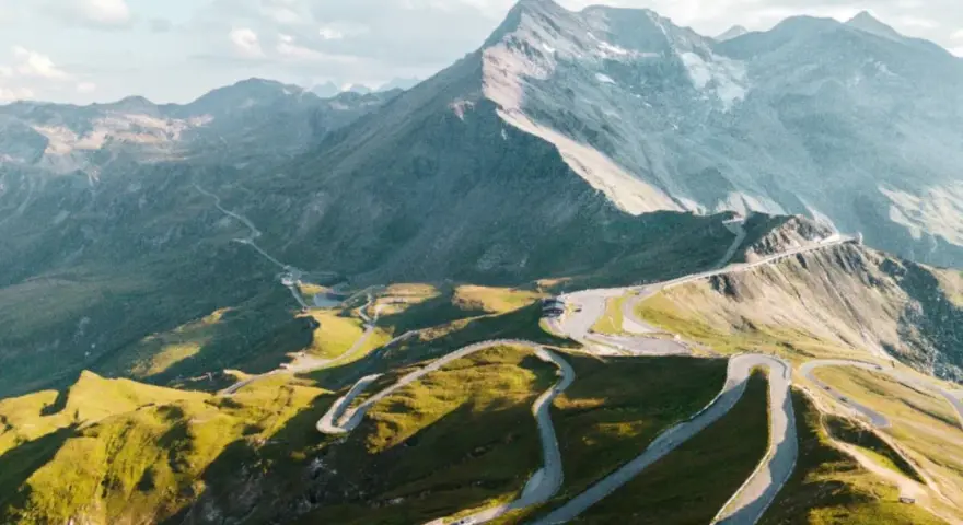 Strada tortuosa in montagna, ideale per un'avventura in moto in Austria. Panorami mozzafiato e curve infinite.