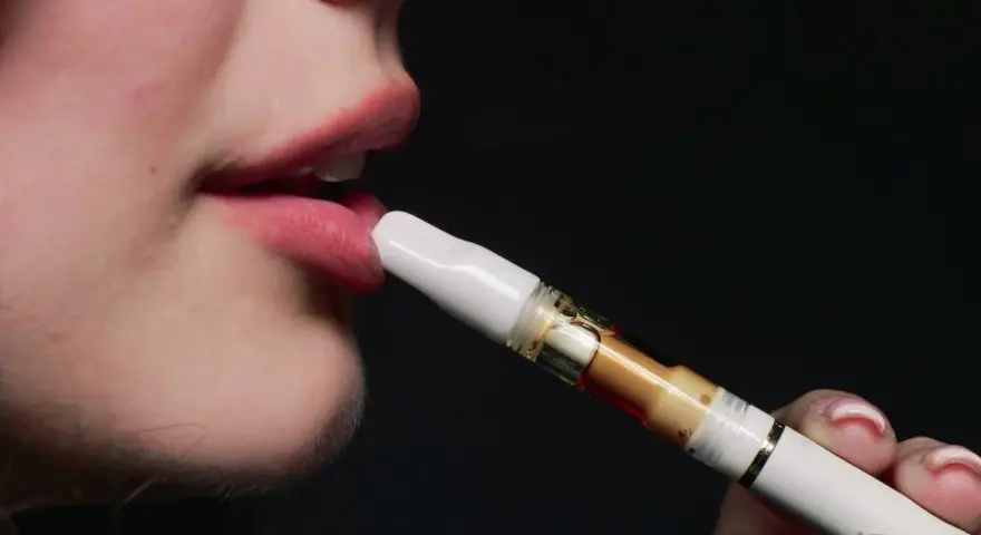Boca de joven usando un vaper sin nicotina. ¿Qué pasa si fumas vaper sin nicotina con 12 años?