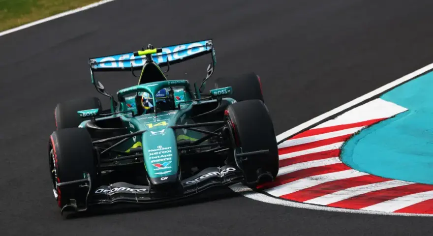 El coche Aston Martin F1, con el número 14, acelera en una curva.