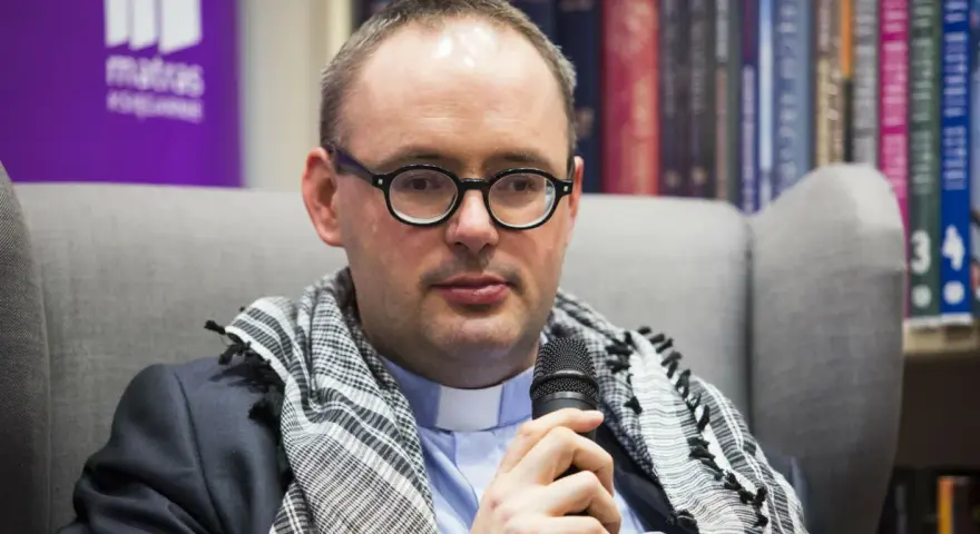 Ksiądz Kaczkowski, w okularach i z szalem, dzieli się cytatami o życiu.