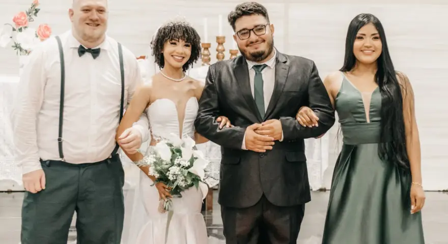 Sposi con due testimoni, un uomo e una donna, sorridono felici. Il rito civile quanti testimoni? Due sono sufficienti per suggellare l'amore.