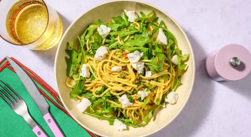 Spaghetti med ruccola och fetaost, ett enkelt zucchini recept. Serveras med ett glas bubbel.