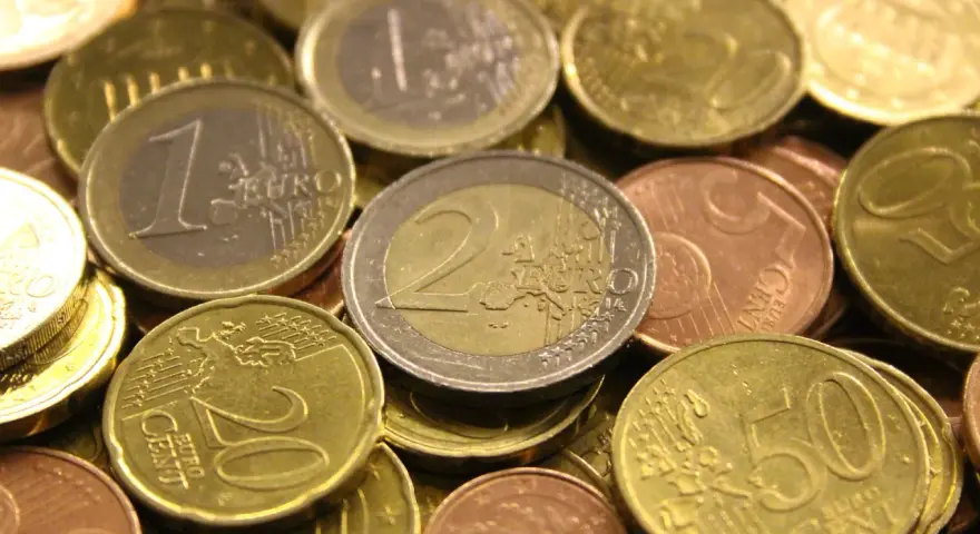 Gros plan sur une pile de pièces en euros de 2002. On distingue des pièces de 1 euro, 2 euros, 20 centimes et 50 centimes.