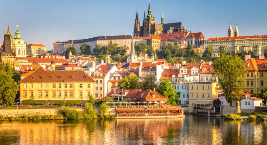 Widok na malownicze praga miasto z rzeką w tle, z dominującym Zamkiem Praskim i katedrą.