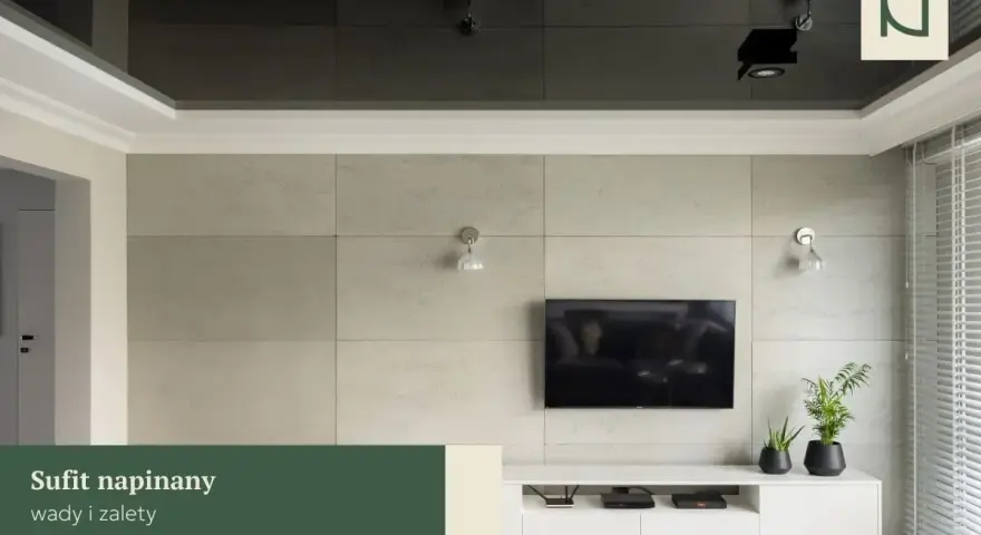 Nowoczesny salon z telewizorem na tle betonowej ściany. Lustrzany sufit napinany dodaje głębi, a subtelna **faseta** podkreśla elegancję wnętrza.