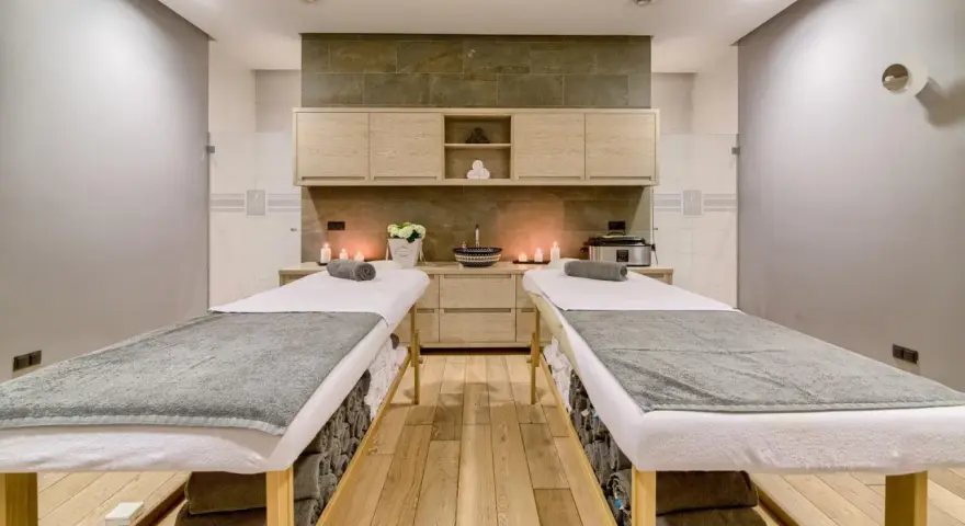 Dwie leżanki do masażu, świece i kwiaty tworzą atmosferę relaksu. Idealne miejsce na 2-dniowy pobyt w spa dla dwojga.