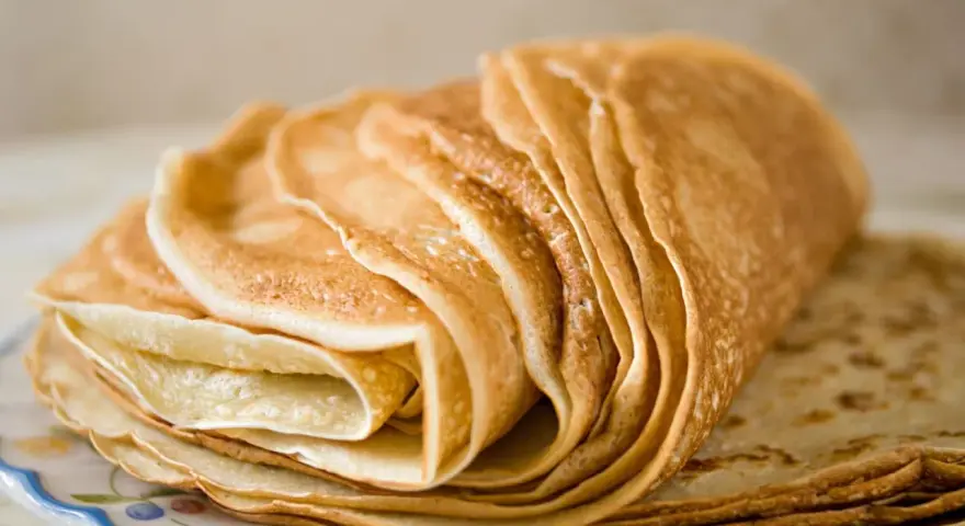 Pile de crêpes dorées, parfaites pour une recette crêpe sans beurre. Elles sont fines et légères, prêtes à être garnies.