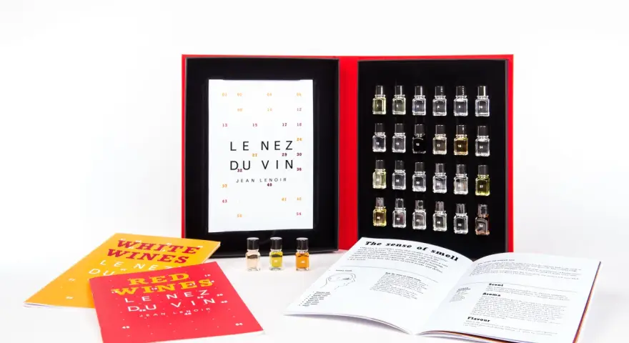 Kit de degustación "Le Nez du Vin" con pequeños frascos de aromas, libros y una tabla de cata.