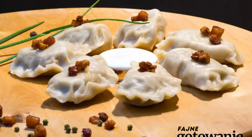 Pyszne pierogi ruskie kontra pierogi z mięsem, podane na desce z chrupiącym skwarkami i śmietaną.