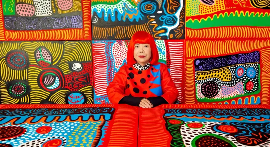 Yayoi Kusama, entourée de son univers psychédélique, une explosion de couleurs vives et de pois emblématiques.