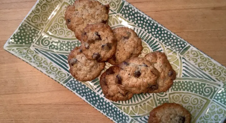 Leckere sauerteig cookies mit Schokoladenstückchen auf einer grünen, gemusterten Platte.