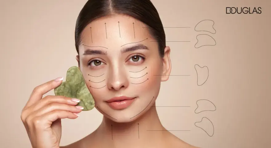 Frau mit Gua Sha Stein im Gesicht, Pfeile zeigen die Anwendungsrichtung. Entdecke, was Gua Sha bringt für deine Hautpflege.