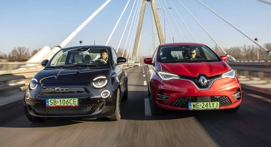 Czarny fiat elektryczny i czerwony samochód jadą po moście.