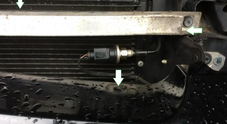 Ein Teil des Kühlergrills mit einem angeschlossenen hochdruckgeber g65. Grüne Pfeile zeigen auf Befestigungspunkte.